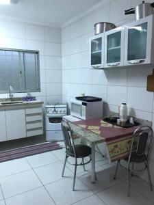 巴乌鲁Casa - Chácara Bella Arraes的白色的厨房配有桌子和两把椅子