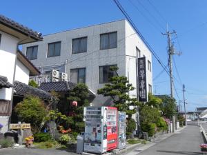 米子市水香园日式旅馆 的街道前方的建筑,配有冰箱