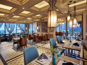 河内Aira Boutique Hanoi Hotel & Spa的一间带桌椅和吊灯的餐厅