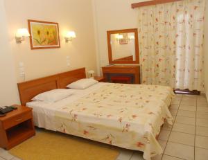 奥林匹亚克农尼欧酒店的一间卧室配有床、水槽和镜子