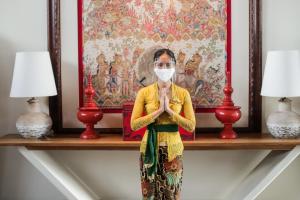 金巴兰巴厘岛百丽宫度假酒店的戴面具在画面前祈祷的女人