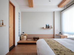 新竹或者风旅的一间卧室设有一张大床和一个窗户。