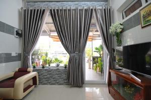 大叻Villa SEVENBAY的客厅设有大窗户和窗帘