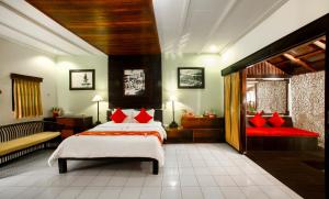 罗威那Bali Taman Lovina Resort & Spa Suites的一间卧室配有两张带红色枕头的床