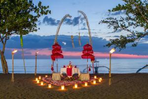 罗威那Bali Taman Lovina Resort & Spa Suites的海边的一张带蜡烛的桌子