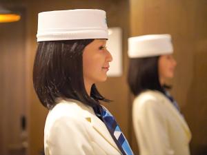 东京Henn na Hotel Tokyo Ginza的身穿镜子前身穿制服的妇女