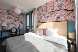 波兹南索雷城精品酒店的一间卧室设有一张带花卉墙壁的大床