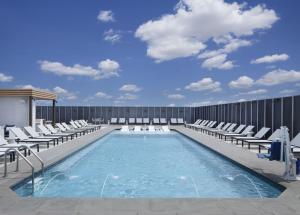 弗赖拉辛Hyatt Regency Frisco-Dallas的大楼内一个带躺椅的游泳池