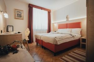 帕苏德尔托纳莱Hotel Bezzi的一间卧室配有一张带橙色床头板的大床