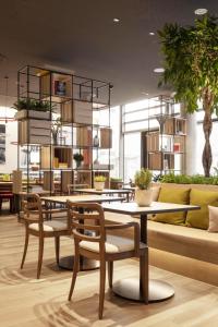 希尔德斯海姆IntercityHotel Hildesheim的餐厅设有桌椅和沙发。