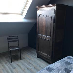 韦斯特卡佩勒D'n Wasschappelsen Engel Windkracht 11的一间卧室配有木制橱柜和椅子