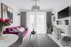 弗罗茨瓦夫Luksusowy apartament Hercena7 w sercu miasta的客厅配有紫色沙发和桌子