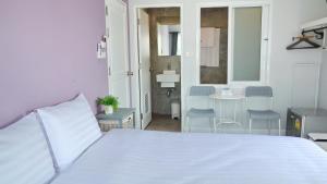 卡塔海滩Kata Bai D - SHA Certificate Hotel的卧室配有白色的床和桌椅