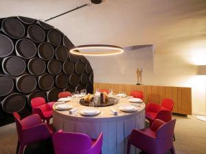 梅斯La Citadelle Metz MGallery的一间带圆桌和红色椅子的用餐室