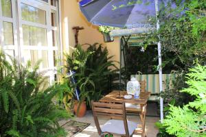 蒙德罗Il Giardino di Laura Private Rooms Mondello的桌椅,带雨伞和植物