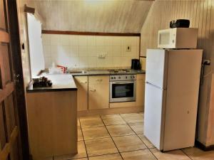 格拉斯科普祖尔滕矿区山林小屋的厨房配有白色冰箱和炉灶。