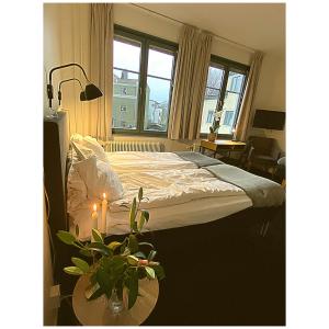 韦克舍瓦润德酒店的一间卧室配有一张床和一张植物桌子
