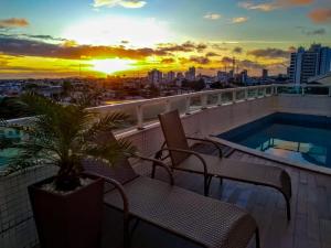 费拉迪圣安娜艾特莫斯费拉酒店的一个带椅子的阳台和一个享有日落美景的游泳池