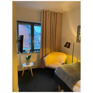 韦克舍瓦润德酒店的酒店的客房 - 带一张床、椅子和窗户