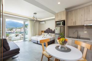 巴利恩Akrogiali Apartments的厨房以及带床和桌子的客厅。