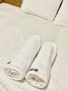 台中市長月居的两条滚毛巾(放置在床上)