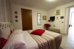 菲乌米奇诺永恒公寓的一间卧室配有一张带红色枕头的床