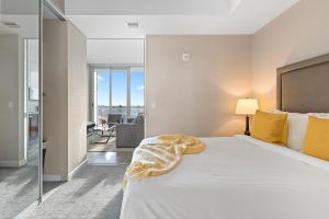 渥太华SOHO Residences Lisgar的卧室配有一张带黄色枕头的大型白色床。