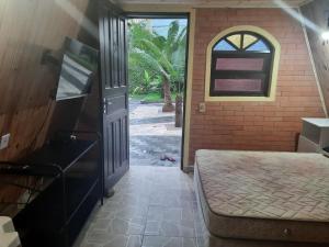 乌巴图巴Chalés Monções的通往带床和窗户的房间的门