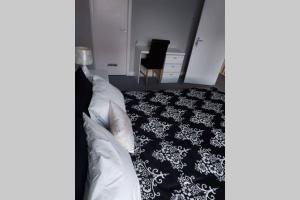 考文垂Wonderland Guest House的一间卧室配有一张铺有黑白色地毯的床
