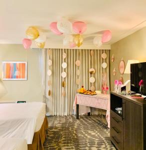 阿罕布拉GreenTree Inn & Suites Los Angeles - Alhambra - Pasadena的一间设有一张床和一张带气球的桌子的房间