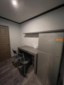 罗勇卡普迪恩酒店的厨房配有冰箱和桌椅