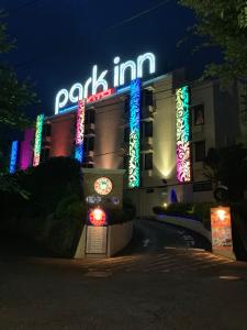 MatsuyamaHotel Park Inn (Adult Only)的上面有很多 ⁇ 虹灯标志的建筑