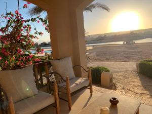 赫尔格达One-Bedroom apartment ground floor for Rent in El Gouna的一个带两把椅子的门廊,享有海滩美景