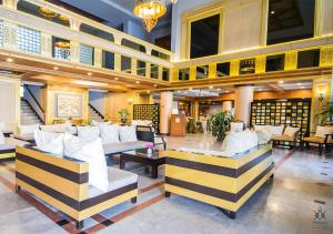 乌汶Tohsang Heritage Ubon Ratchathani Hotel的大厅,在大楼里设有沙发和桌子