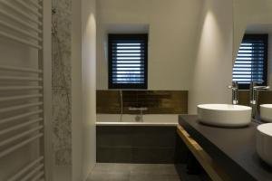 罗森达尔中心酒店的一间带两个盥洗盆、浴缸和窗户的浴室
