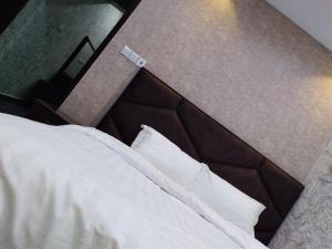 阿尔卡吉Iwaa Alkharj Apartments的一间卧室配有带白色床单和枕头的床。