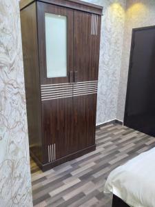 阿尔卡吉Iwaa Alkharj Apartments的卧室设有1个带门的大型木制衣柜