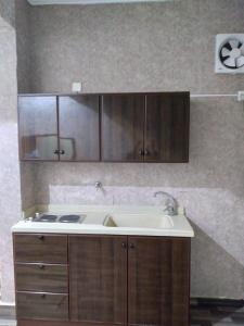 阿尔卡吉Iwaa Alkharj Apartments的一个带水槽和木橱柜的厨房