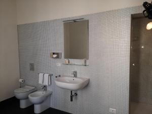 科米索Palazzo Melfi的一间带水槽、卫生间和镜子的浴室
