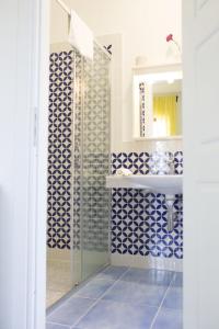 圣多米尼卡B&B Il Cavaliere Tropea的浴室铺有蓝色和白色瓷砖,配有水槽