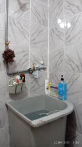 居林Ketupat Palas Homestay的浴室铺有白色瓷砖,配有浴缸。