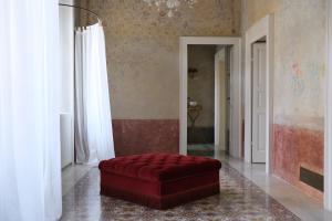科莫阿布里奇佩雷利尼宫旅馆的一间客厅,在房间内配有红色的搁脚凳