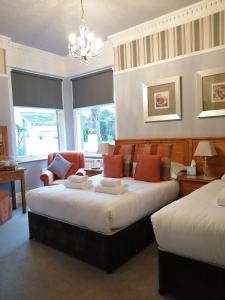 鲍内斯温德米尔奥克弗尔德别墅酒店的一间卧室配有两张床和吊灯。