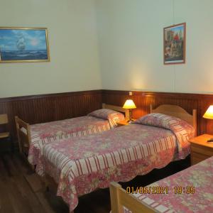 瓦尔帕莱索Hostal El Rincon Marino的酒店客房设有两张床和两盏灯。