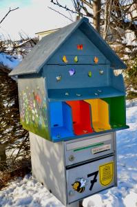 TramelanLa Ruche的雪中带蓝色屋顶的玩具鸟屋