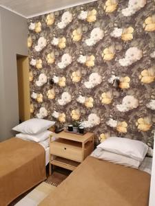 珀尔察马卡尔施密特旅馆的一间卧室设有两张床,墙上有鲜花