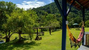 维奥康德马奥Hotel Fazenda Pedra Grande的公园内的吊床,设有野餐桌和树木