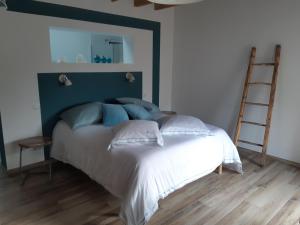 Saint-Paul-dʼUzoreLes Ronzières的一间卧室配有一张白色的床和蓝色床头板