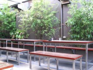 悉尼史卓菲酒店的一组桌子和长椅,上面有植物