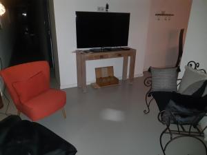 Saint-Paul-dʼUzoreLes Ronzières的客厅配有红色椅子和电视
